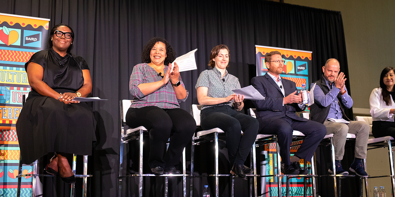 Panel presenters on stage at the Baird Multicultural Community Conference