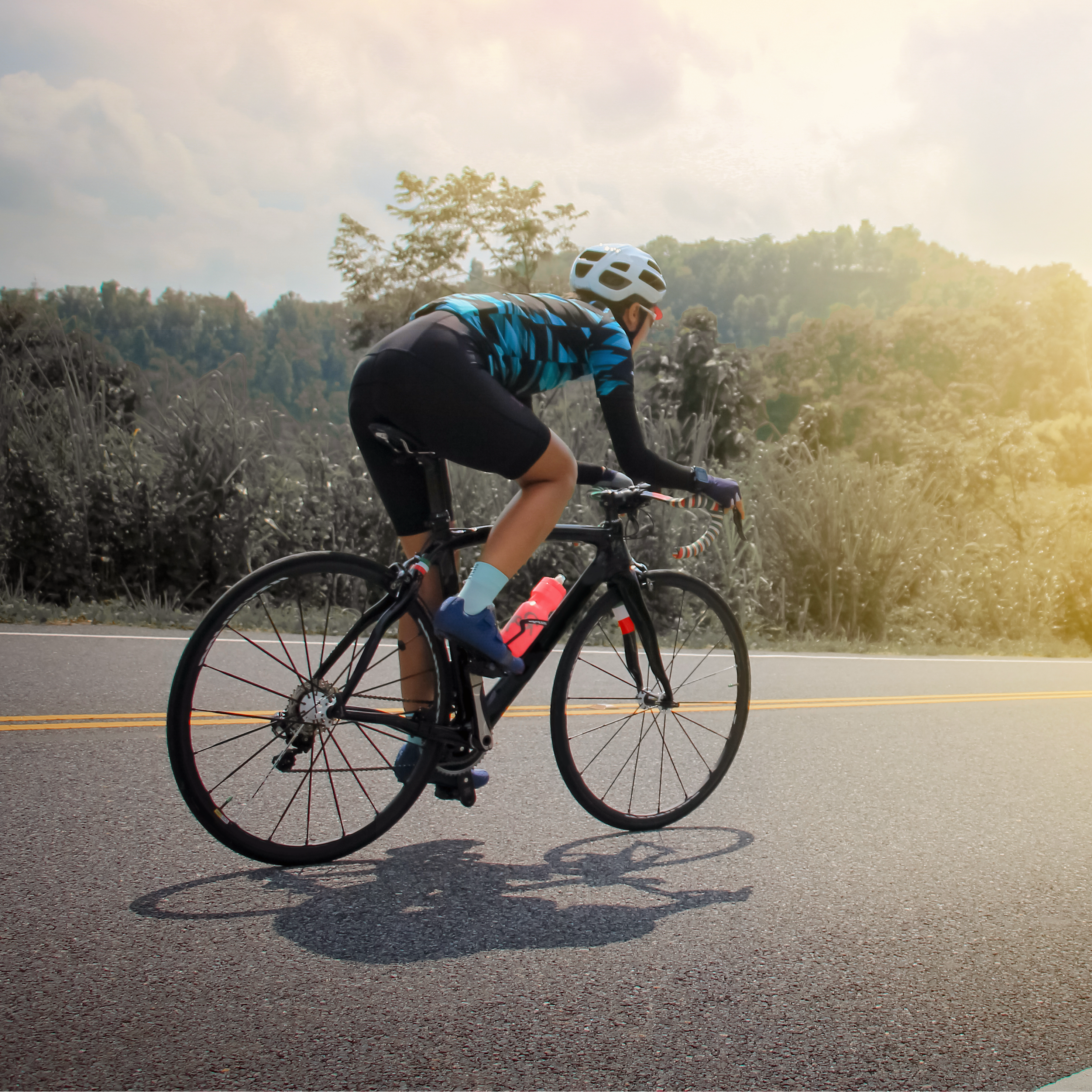 Person riding bicycle on a rural road.