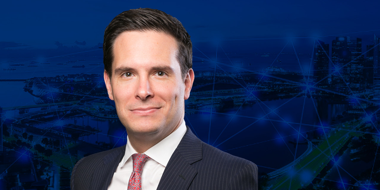 Headshot of Christopher Verrone with an abstract blue background.