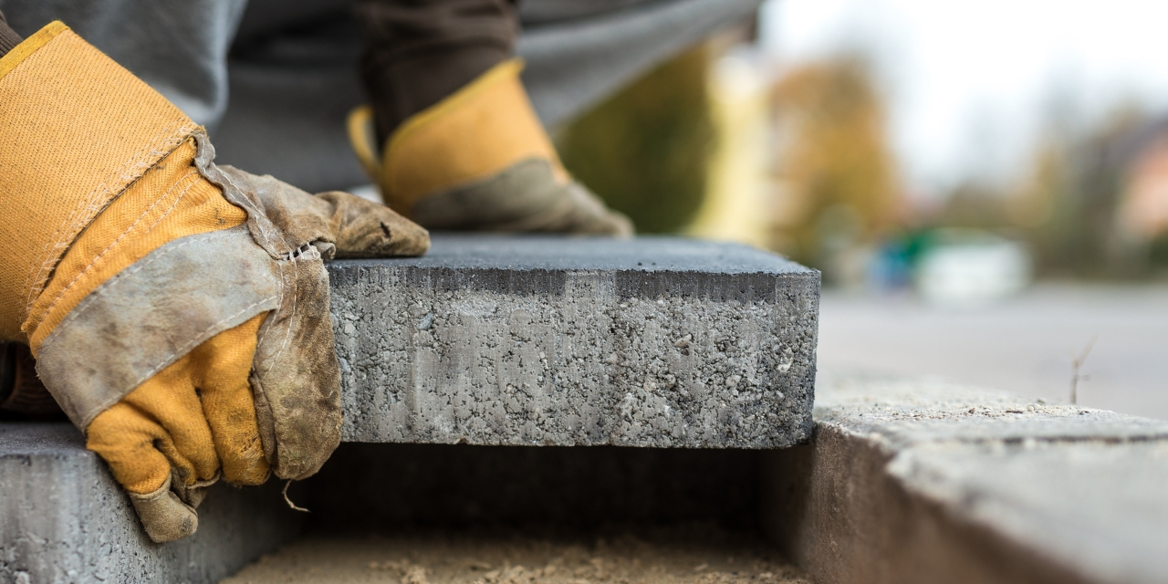 Hands laying bricks.