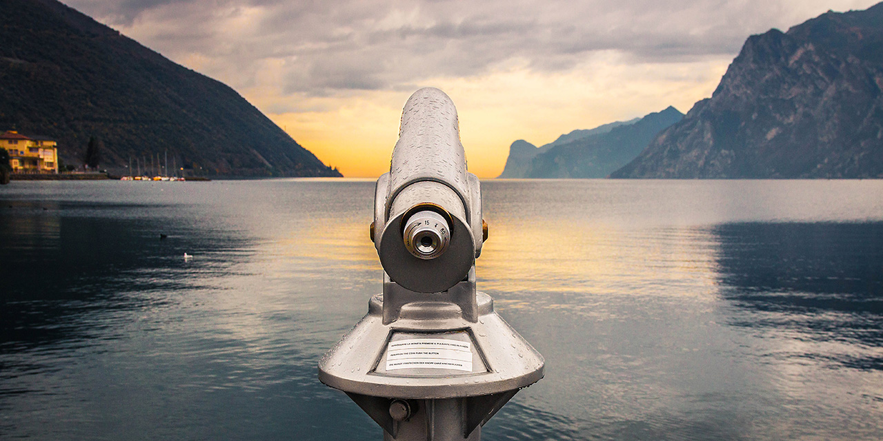 Telescope pointed over large body of water.