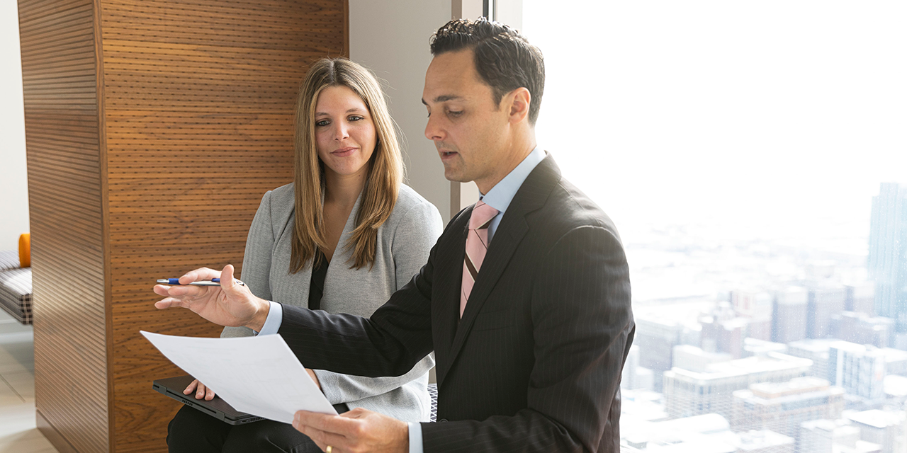 Baird Fixed Income Capital Markets associates talking in front of a window in Chicago