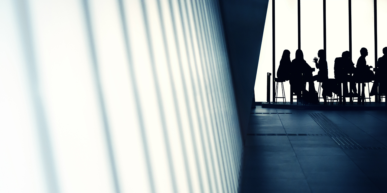 People sitting at tables in a business setting.