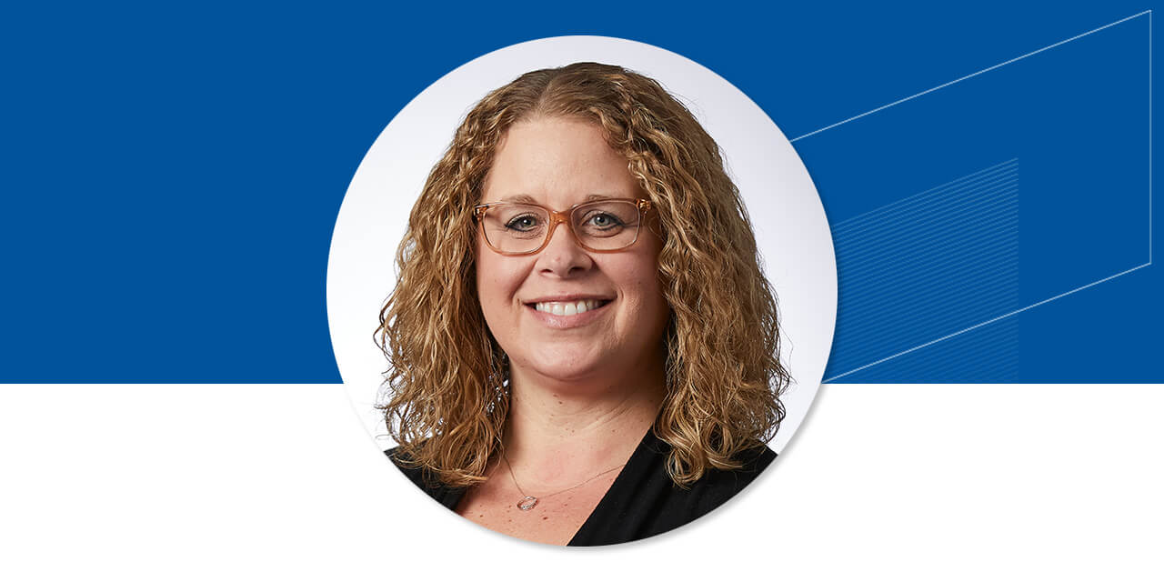 Headshot of Erica Kroll on a blue background with an abstract Baird logo
