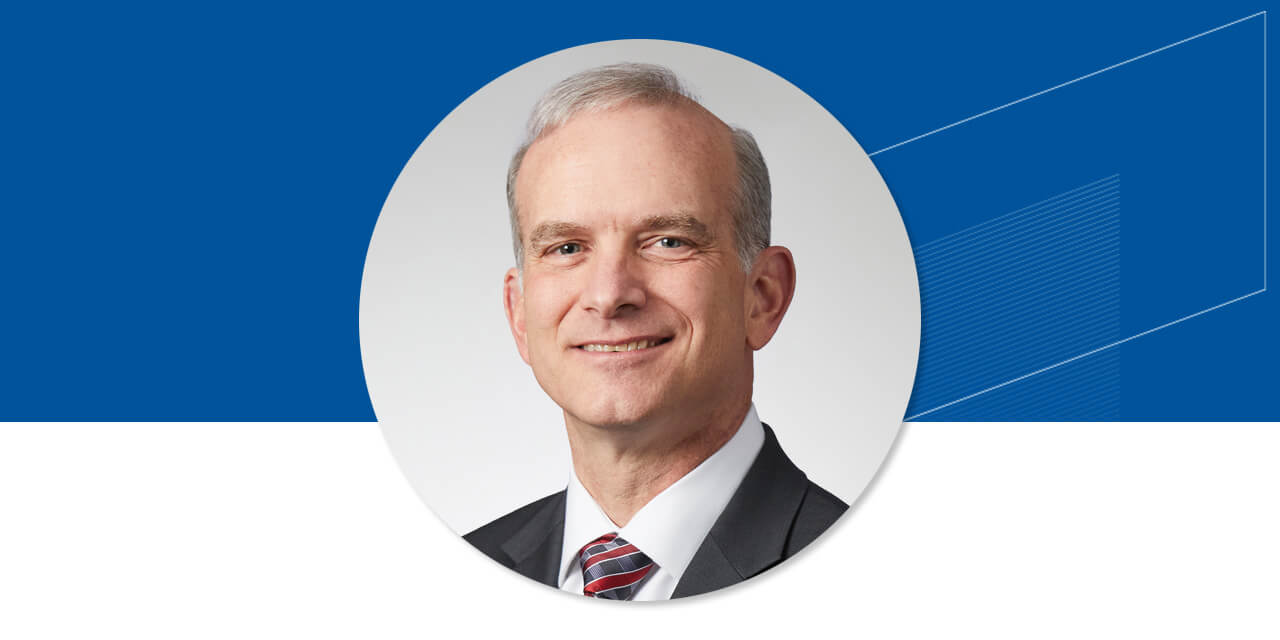 Headshot of Tim Steffen on a blue background with an abstract Baird logo