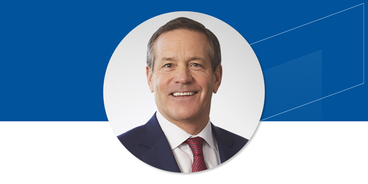 Headshot of John Taft on a blue background with an abstract Baird logo