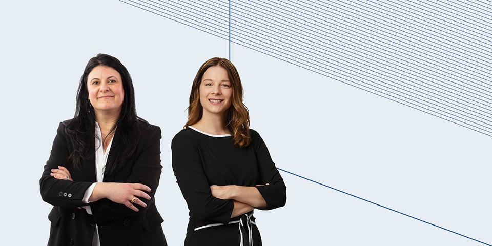 Two professional women with arms folded across chest