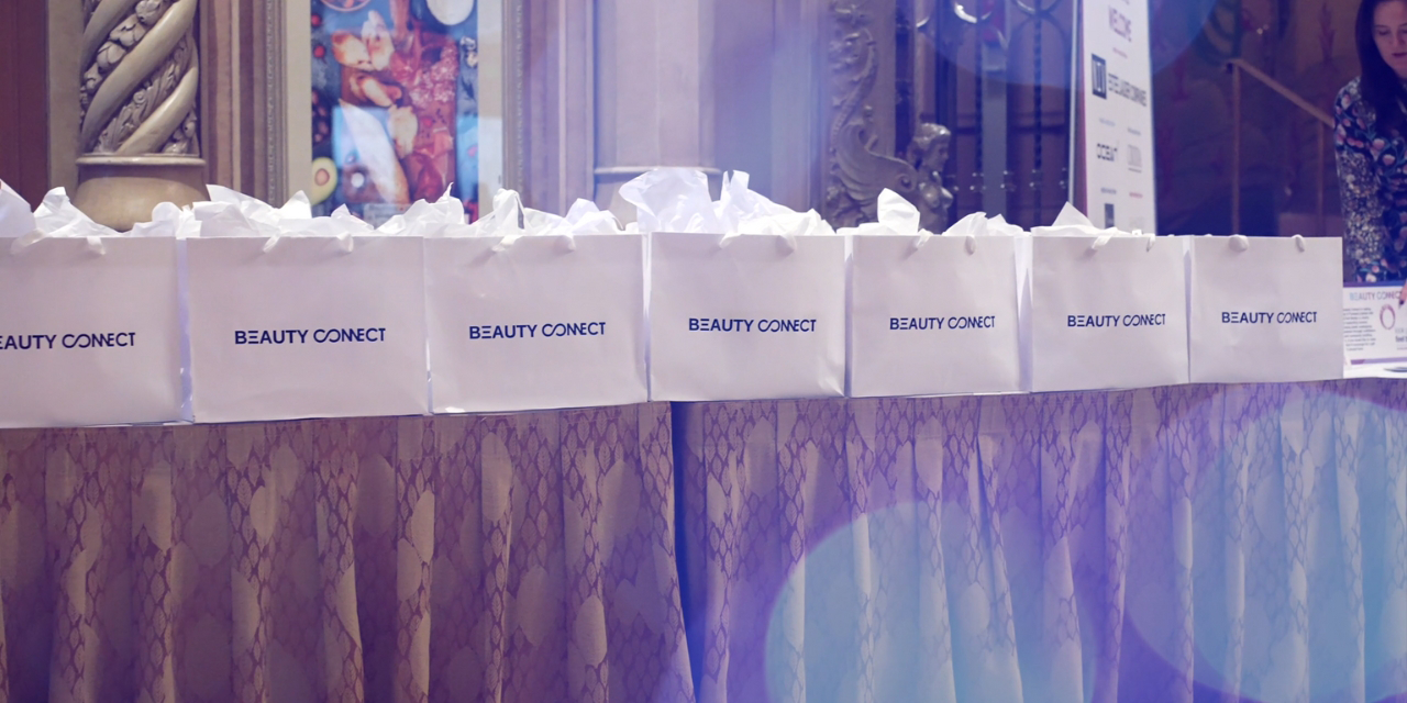 Swag bags from Beauty Connect LA 2023 sitting on a display table.