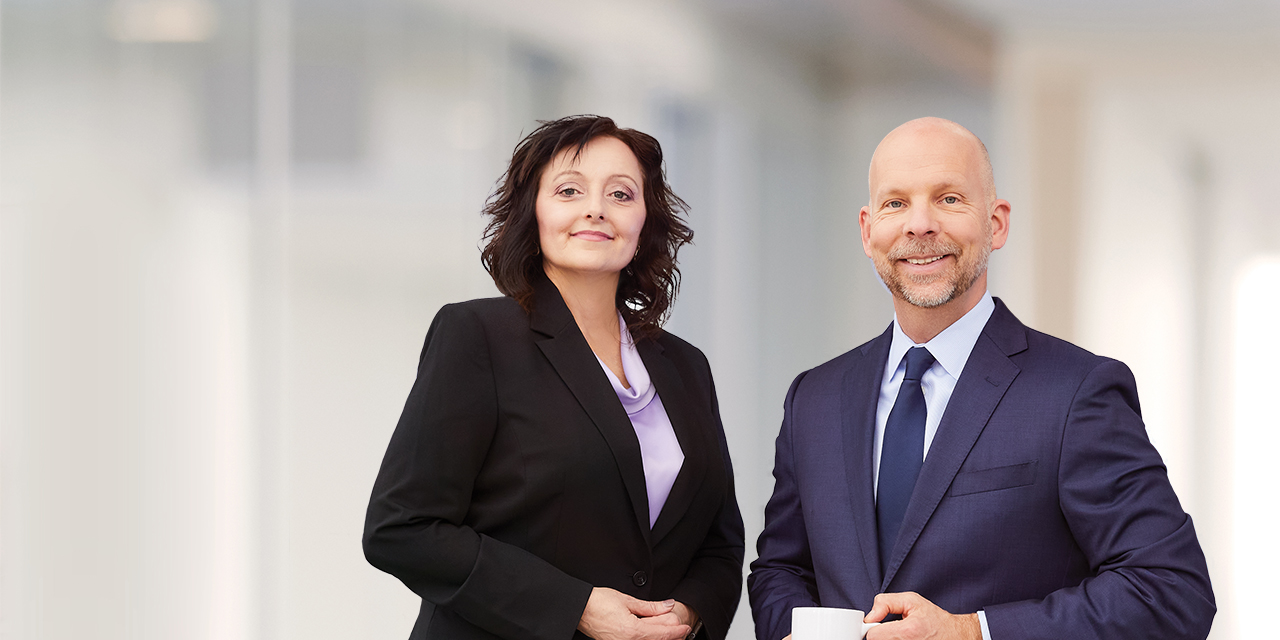 Two of Baird's Louisville executives standing and smiling.